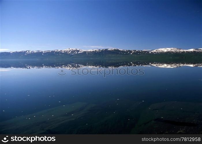 Mirrow lake with snow mountain in Norway