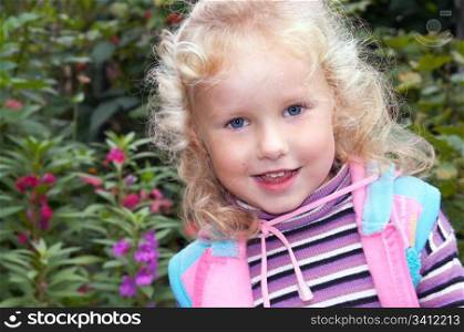 mischievous mistrustful little girl in ornamental garden
