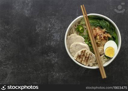 Miso Ramen Asian noodles with egg, chicken, and pak choi cabbage in bowl. Japanese cuisine. Top view, copy space for recipe or text.