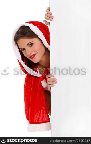 Miss Santa peeking round a board left blank for your message