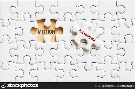 Mission and accomplish words on jigsaw puzzle background, business concept