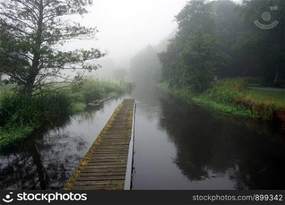 Mist and pier on the river in Denmark