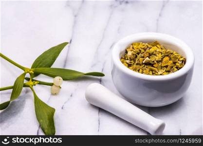 mistletoe, medicinal herb dried and fresh leaves with mortar