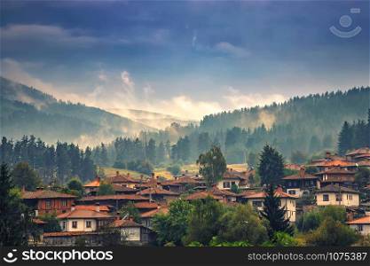 Misty landscape mountain view over the beautiful wooden houses of the village