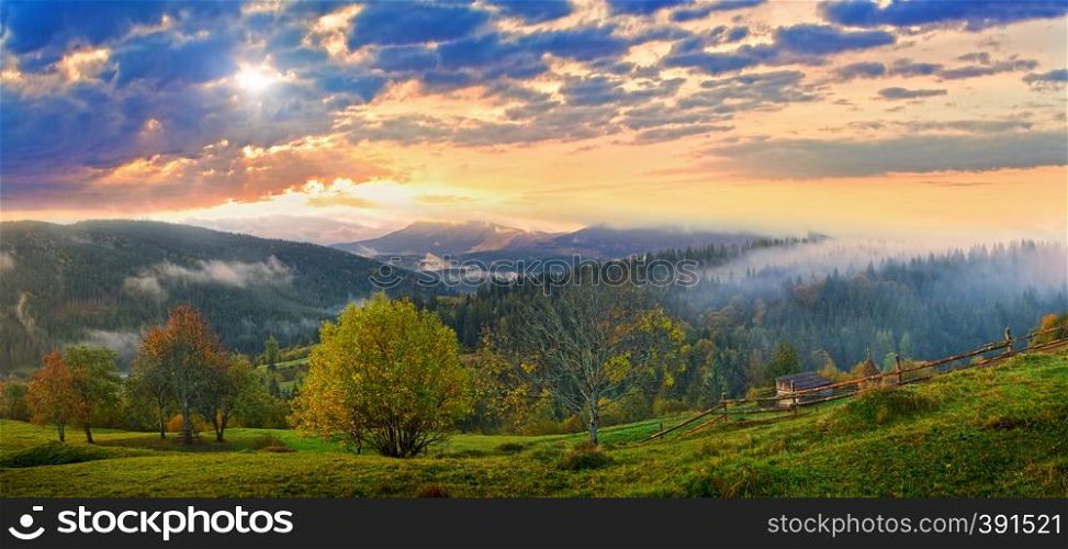 Misty morning and sunshine thru clouds in autumn Carpathian mountain, Ukraine. High resolution stitch panorama image.