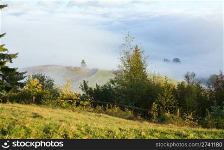Mistyl autumn morning near Carpathian village outskirts (Ukraine).