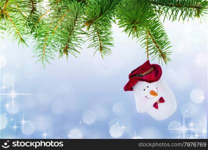 Mitten Snowman on the Christmas Tree at the Defocused Lights Background .