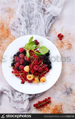 mix berries on plate and on a table