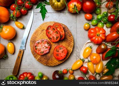 Mix colorful tomatoes in summer day. Composition of variety fresh tomatoes. Rustic style gray background. Top view.. Mix colorful tomatoes