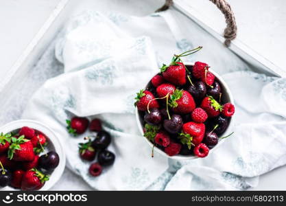 Mix of berries on white rustic background