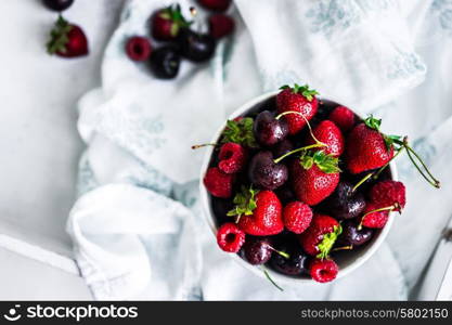 Mix of berries on white rustic background