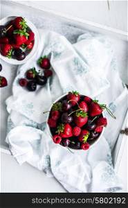 Mix of berries on white rustic background