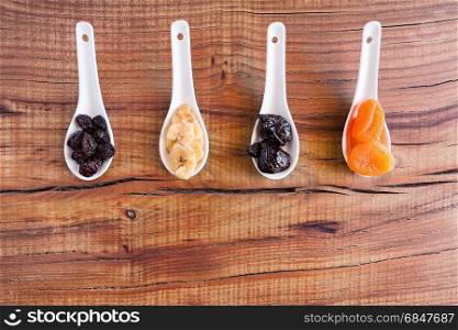 Mix of dried fruits over a rustic table seen from above. Mix of dried fruits over a rustic table