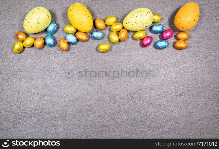 Mix of easter eggs of all colors and sizes on a gray granite stone background. Easter concept.. Mix of easter eggs of all colors and sizes on a gray granite stone background. Easter concept