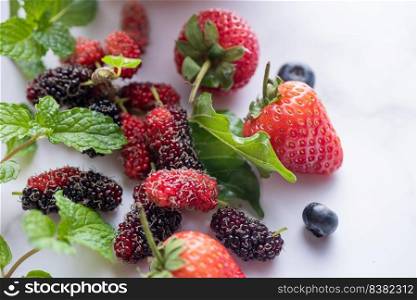 Mix of fresh berries isolated fresh blueberries, mulberry, strawberries, mint board for copy space. Healthy concept. Clean eating.