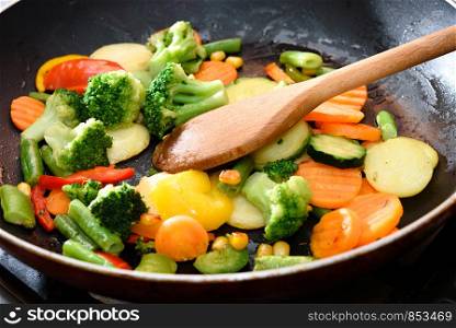 Mix of fresh vegetables fried in the pan in close-up.