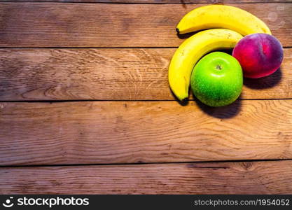 Mix of fruits on wooden table. Banana, apple, nectarine