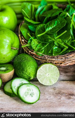 Mix of green fruits and vegetables on rustic wooden background