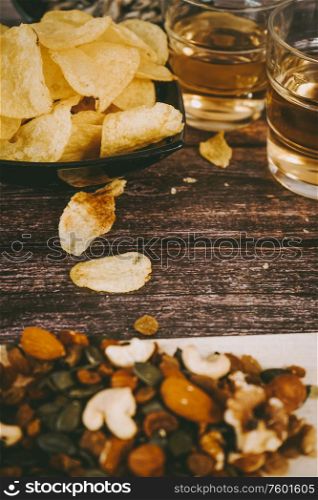 Mix of snacks with chips, nuts, seeds and beer