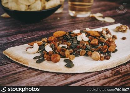 Mix of snacks with chips, nuts, seeds and beer