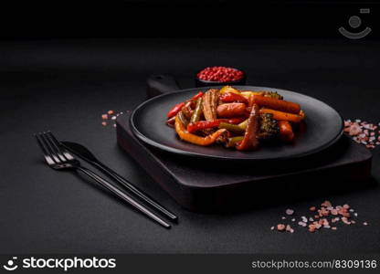 Mix of vegetables corn, carrots, peppers, broccoli, onions in teriyaki sauce on a ceramic plate on a dark concrete background