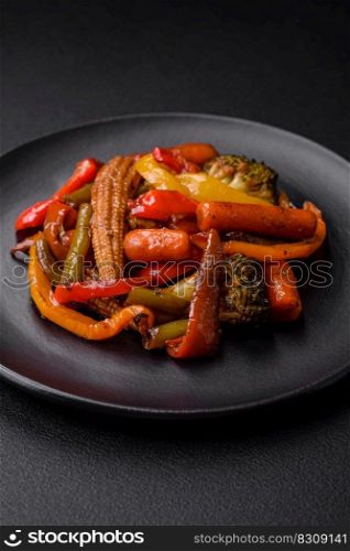 Mix of vegetables corn, carrots, peppers, broccoli, onions in teriyaki sauce on a ceramic plate on a dark concrete background