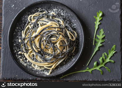 Mix of white and black pasta with cheese in the bowl