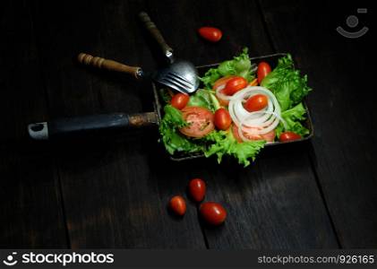 Mix vegetable salad in pan on dark background, clean food concept