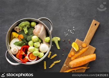 mix vegetables chicken drumstick pan with carrot cutting board
