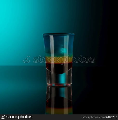 mixed alcoholic liquor in a shot glass isolated on a dark background with backlighting. shot glass with alcohol on a dark background