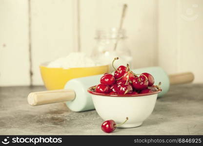 Mixed berries, baking ingredients and utensils on rustic background