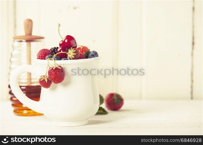 Mixed berries in a cup on rustic background