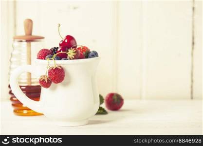 Mixed berries in a cup on rustic background