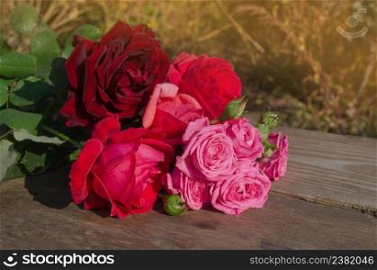 Mixed colorful roses full blooming. Beauty roses flowers. Fresh garden flowers on wooden table.. Floral composition with roses. Mix color roses
