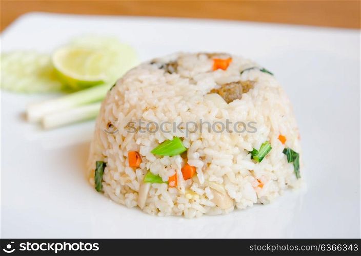 Mixed cooked rice with fried fish and sauce , served with fresh vegetable