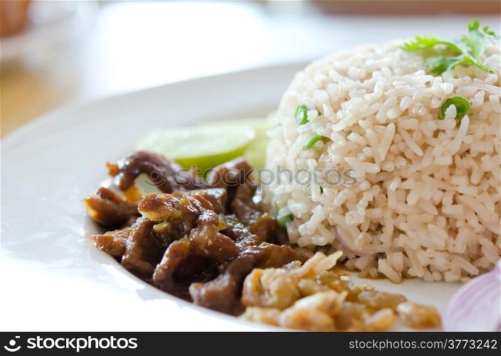 Mixed cooked rice with pork sauce and fresh vegetable , Thai favorite food of rice