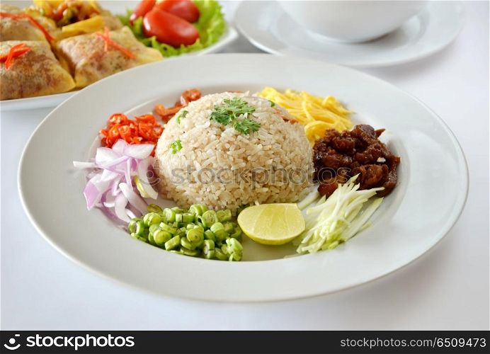 Mixed cooked rice with shrimp paste sauce and fresh vegetable , Thai food on table