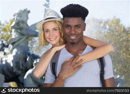 mixed couple in love hugging outdoors