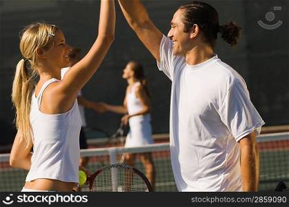 Mixed Doubles Partners High-Fiving Each Other