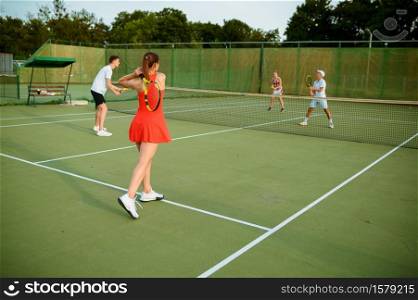 Mixed doubles tennis players, outdoor court. Active healthy lifestyle, people play sport game with racket and ball, fitness workout. Mixed doubles tennis players, outdoor court