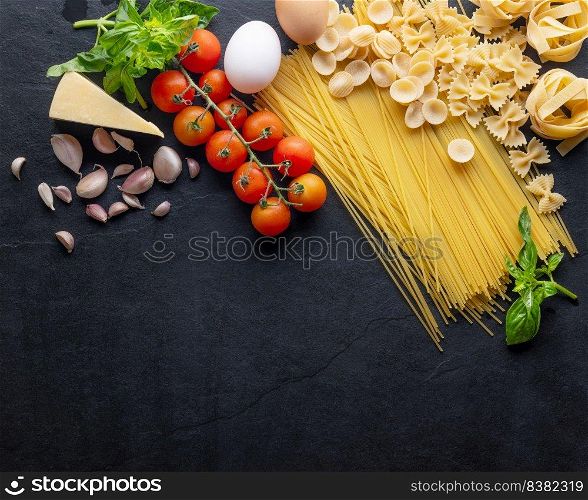 Mixed dried pasta selection. composition of healthy food ingredients isolated on black stone background, top view, Flat lay