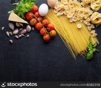 Mixed dried pasta selection. composition of healthy food ingredients isolated on black stone background, top view, Flat lay