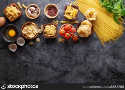 Mixed dried pasta selection on stone background. composition of healthy food ingredients isolated on black stone background, top view, Flat lay