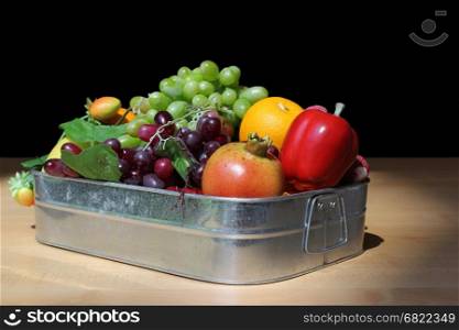 mixed fresh fruits in box on black background