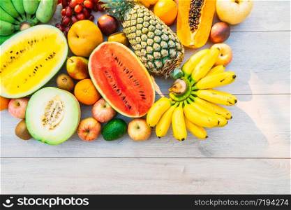 Mixed fruits with apple banana orange and other on wooden background - Healthy food style