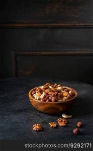 Mixed nuts in a bowl on dark wooden background.. Mixed nuts in a bowl