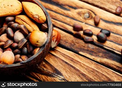 Mixed nuts in a bowl on wooden table.Healthy food. Wooden bowl with mixed nuts