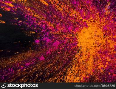 mixed orange pink powder holi colors against black backdrop