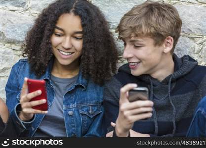 Mixed race African American girl, interracial teenagers boy and girl, male and female, texting and using mobile cell phone
