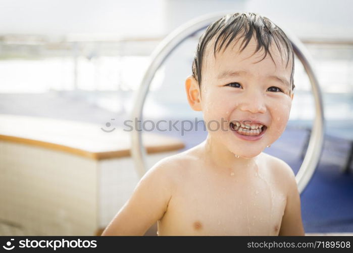 Mixed Race Boy Having Fun at the Water Park with Large Rubber Duck in the Background.